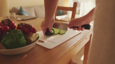 Genç bayan mutfakta salata hazırlıyor.