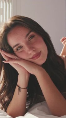 VERTICAL VIDEO, yakın çekim, mutlu kız yatakta yatıyor