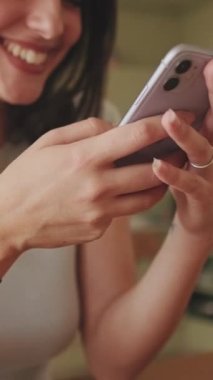 VERTICAL VIDEO, akıllı telefonundaki fotoğraflara ve videolara göz atan kızların yakın çekim görüntüleri.