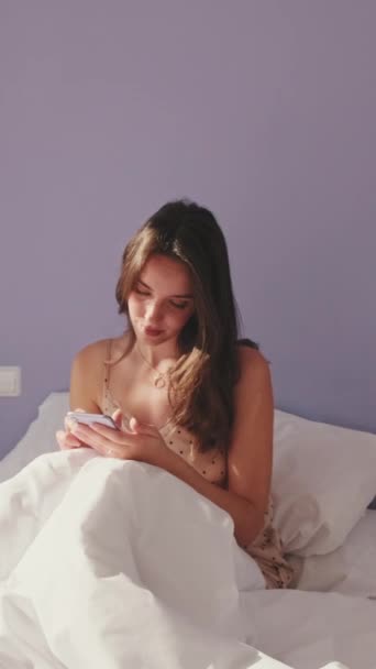 Vertical Video Mutlu Kadın Sabah Uyandıktan Sonra Telefonla Mesaj Atıyor — Stok video