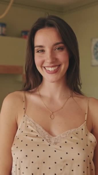 視覚ビデオ 若いです女性でパジャマ笑顔ながらキッチンに立って — ストック動画