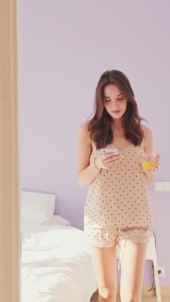 Vertical Video Pijamalı Genç Kadın Camdan Meyve Suyu Içiyor Yatak — Stok video