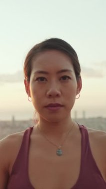VERTICAL VIDEO: Close-up of girl looking at the camera on the old city background