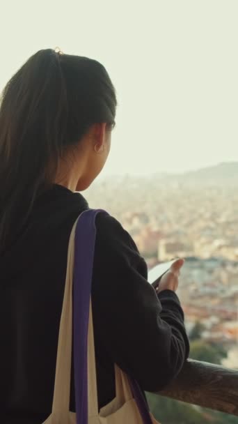 Відео Молода Жінка Стоїть Платформі Перегляду Мобільним Телефоном Руках Дивиться — стокове відео