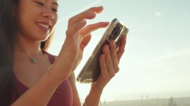 Cep telefonu kullanan genç bir kadının ellerini yakın plan çek.