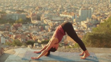 Kız geriniyor, gözlem güvertesinde yoga yapıyor.