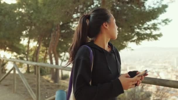Junge Frau Läuft Den Weg Entlang Und Benutzt Handy — Stockvideo