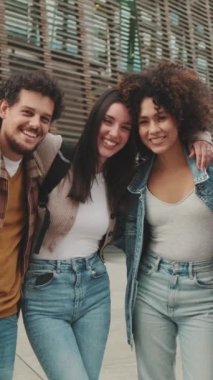 Young smiling people posing while standing on the street