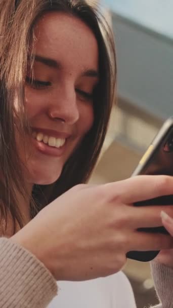 彼女の携帯電話にソーシャルメディアのメッセージを入力して幸せな女の子の肖像画 — ストック動画