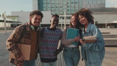 Group of students smiling while looking at camera while standing outside