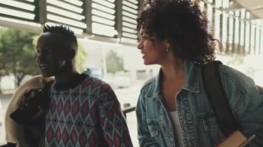 Laughing student couple talking walking together