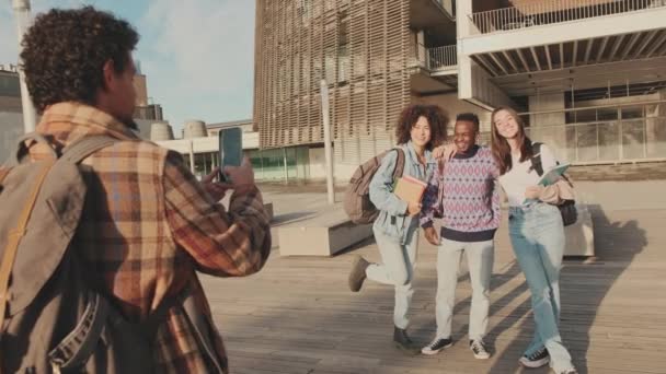 Группа Студентов Улыбается Глядя Камеру Мобильного Телефона Стоя Снаружи — стоковое видео