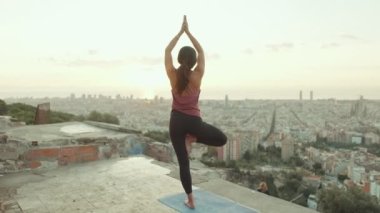 Kız şafak vakti gözetleme noktasında yoga yapıyor.