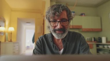 Close-up of senior working on laptop inside