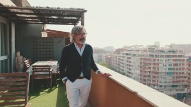 Senier balkondaki manzaranın tadını çıkarıyor.