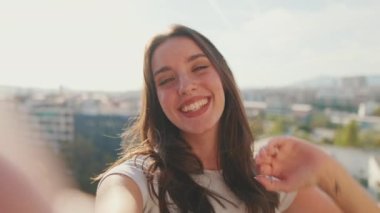 Genç bir kadının balkonda dikilirken el ele görüntüsü.