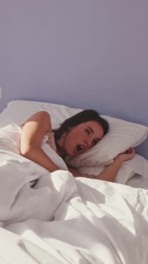 VERTICAL VIDEO, Genç bir kadın uyanıyor ve yatağında uzanıyor