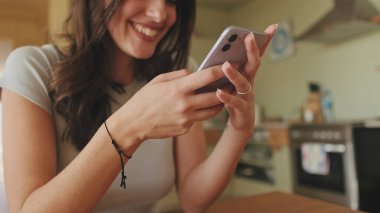 Akıllı telefonundaki fotoğraflara ve videolara göz gezdirirken kızın ellerini yakın plan çek.