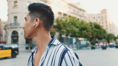 Genç bir turist eski şehrin meydanında yürüyor.