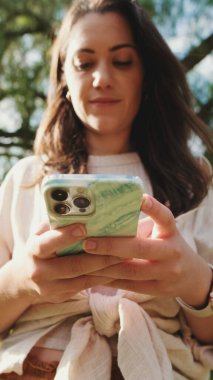 Close-up of young woman's hands using mobile phone. Soft focus