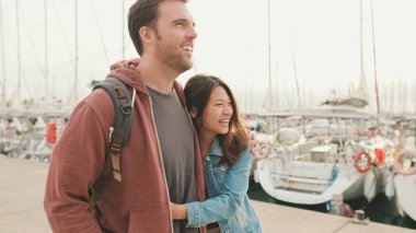 Genç mutlu çift gezinti güvertesinde sarılıyor.