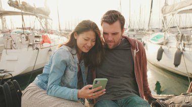 Yaklaşın, danışman çift rıhtımda otururken cep telefonu kullanıyor.