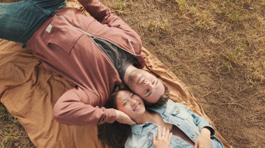 Parkta battaniyeye uzanmış genç bir çift. Yukarıdan görüntüle