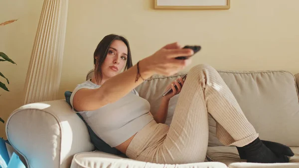 Junge Frau Wechselt Kanäle Mit Fernbedienung Während Sie Hause Auf — Stockfoto