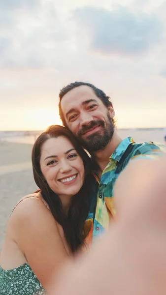 笑夫妻站在海滩上打视频电话 — 图库照片