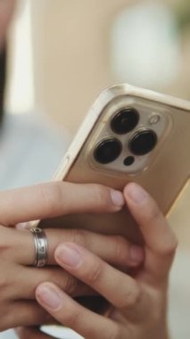Genç bir kadının cep telefonu kullanarak ellerini yakın plan çektir.