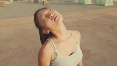 Close up, asian girl in sports top does workout, stretching and gymnastics at morning time