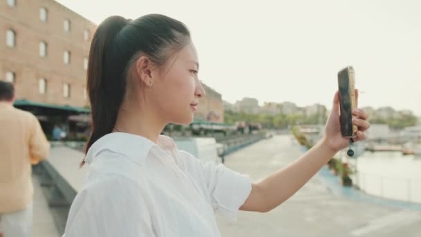 Młoda Kobieta Robi Zdjęcie Portu Morskiego Przez Telefon Komórkowy — Wideo stockowe