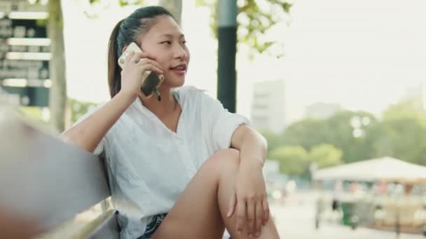 Jonge Vrouw Zittend Een Bankje Praten Mobiele Telefoon — Stockvideo