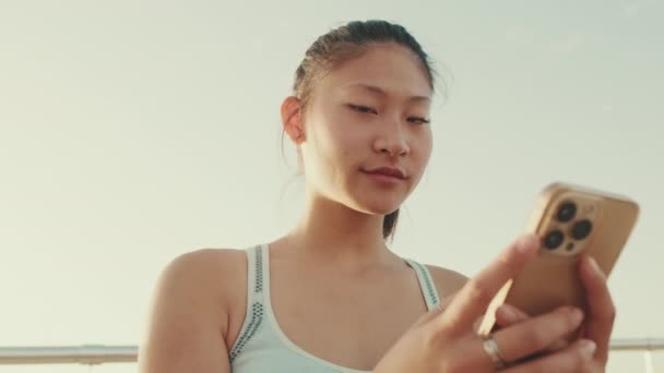 Menina Asiática Esportes Top Senta Beira Mar Usa Smartphone Jovem — Vídeo de Stock