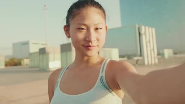 Smiling Asian Girl Sports Top Makes Selfie While Standing Embankment — Stok video
