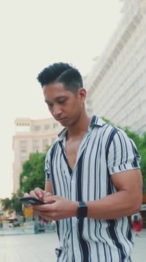 Genç turist, cep telefonunda harita uygulaması kullanıyor.