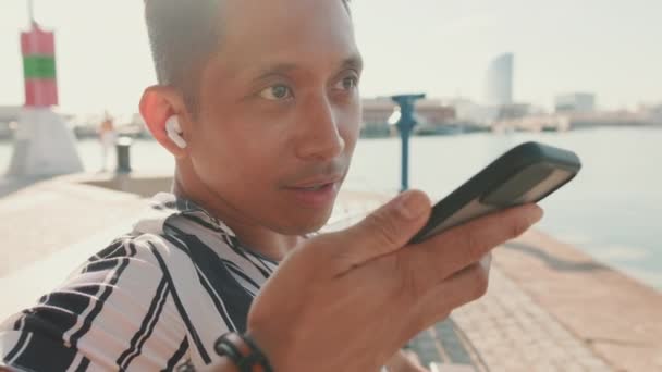 Zblízka Mladý Muž Turista Sedí Lavičce Molu Posílá Hlasovou Zprávu — Stock video