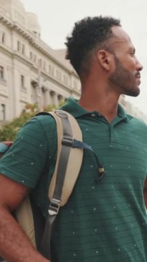 Genç turist, eski şehrin meydanında yürüyor, manzarayı değerlendiriyor.