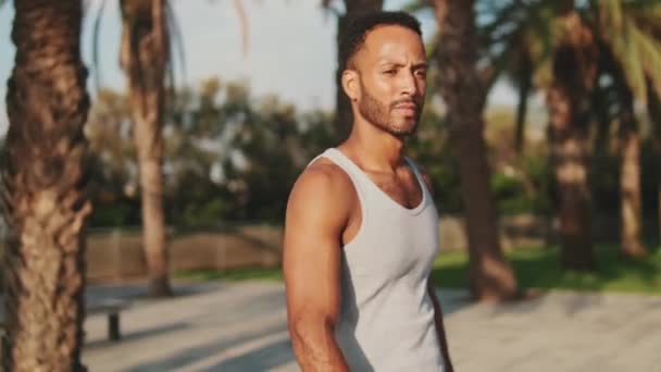 Young Bearded Male Fit Athlete Walks Training Background Palm Trees — Stockvideo