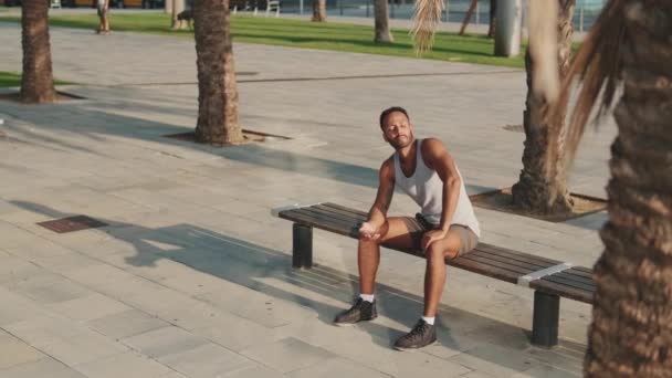 Young Bearded Male Athlete Resting Training Sitting Bench Using Smartphone — Vídeo de stock