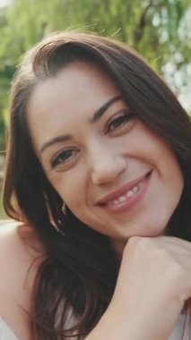 VERTICAL VIDEO: Close up, laughing young woman posing at camera