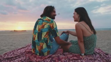 Aşık çift, kumsalda güneşin doğuşuyla tanışır. Arka plan