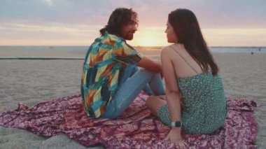 Aşık çift, kumsalda güneşin doğuşuyla tanışır. Arka plan