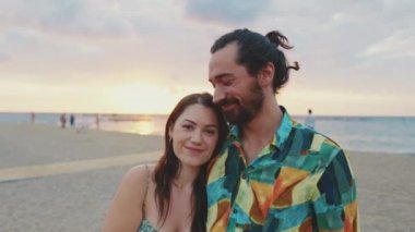 Aşık çift, kumsalda güneşin doğuşuyla tanışır. Arka plan