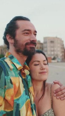 Aşık çift, kumsalda güneşin doğuşuyla tanışır. Arka plan