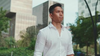 Genç işadamı modern bina arka planında yürüyor.