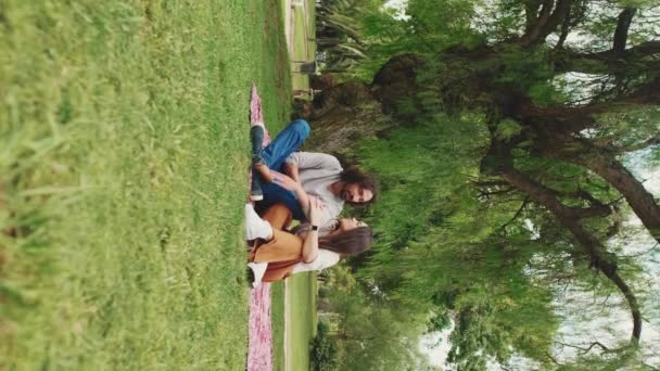Vertical Video Glücklich Lächelndes Paar Park Auf Einer Decke Sitzend — Stockvideo