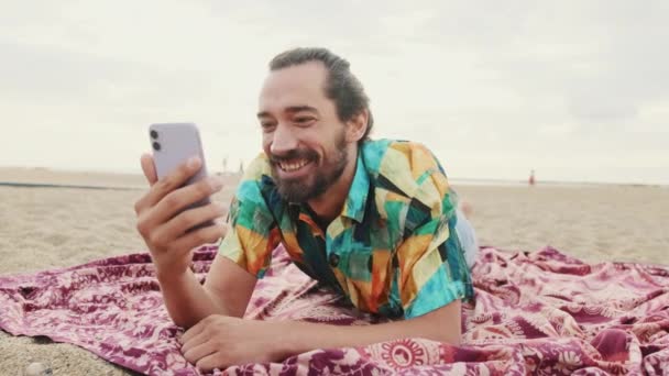 年轻快乐的男人在海滩上通过视频连接通过手机聊天 — 图库视频影像