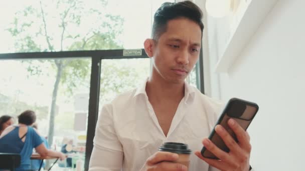 Mladý Podnikatel Sedí Stolu Mobilním Telefonem Pije Kávu Kavárně — Stock video