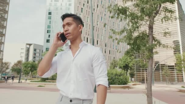 若いビジネスマンがスマートフォンで話している — ストック動画